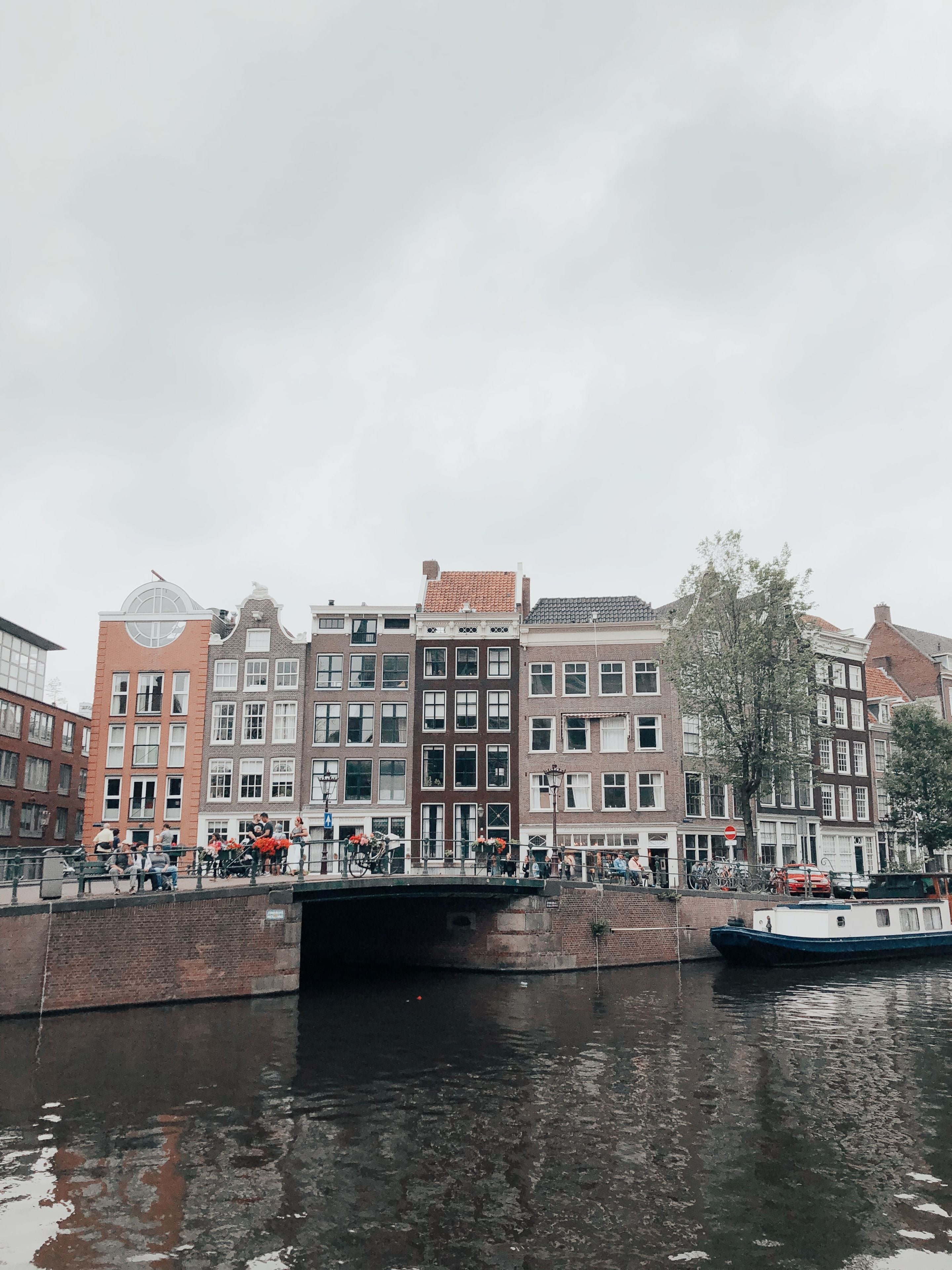 Row of narrow gabled Dutch canal houses beside the water in Amsterdam